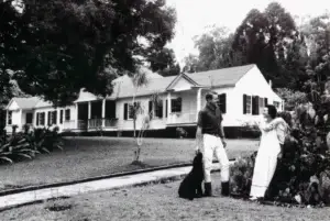 Historic photo of the Ulupalakua Ranch house with a couple on the lawn