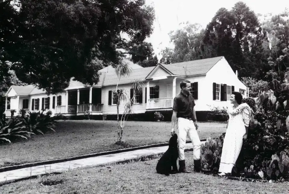 Historic photo of the Ulupalakua Ranch house with a couple on the lawn