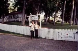 Historic photo of a couple at the Tedeschi Winery sign and white picket fence