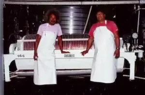 Historic photo of two winery workers at the grape press