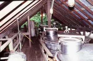 Historic photo of winemaking equipment under the wooden winery roof