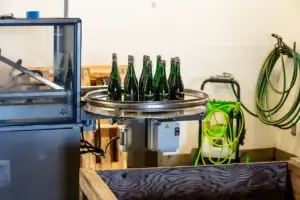Sparkling wine bottles on the filling machine in the winery