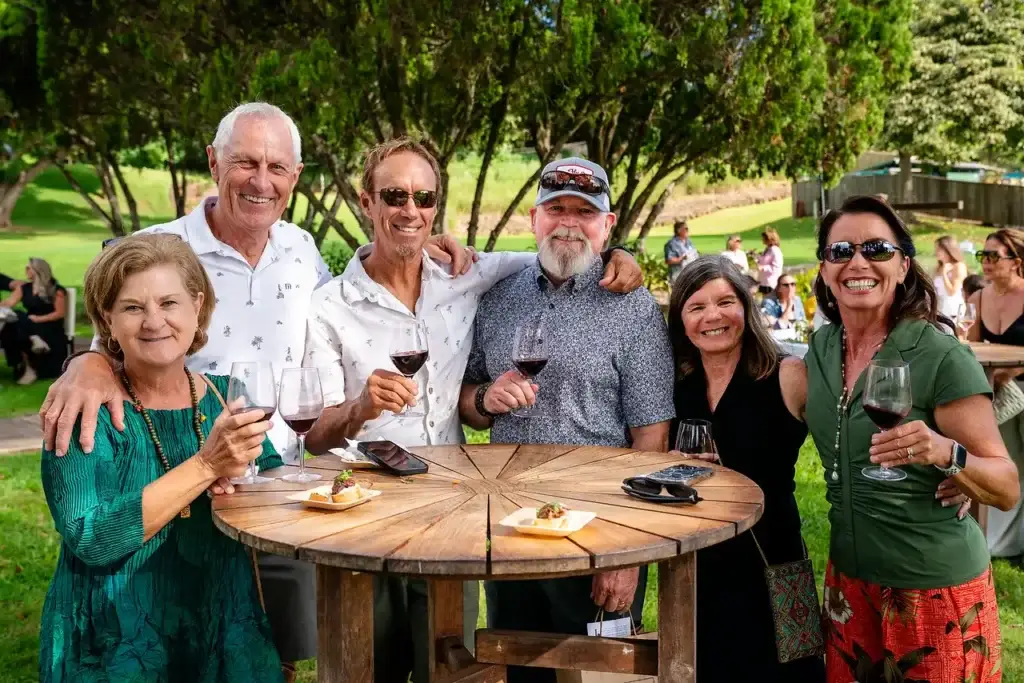 Wine club members toasting together at a garden table