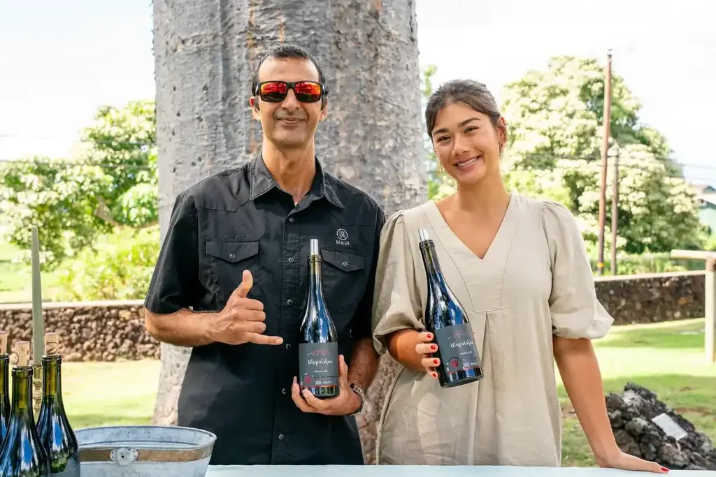 MauiWine staff holding bottles of wine at a club event