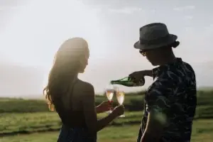 Couple pouring wine outdoors at sunset in Upcountry Maui