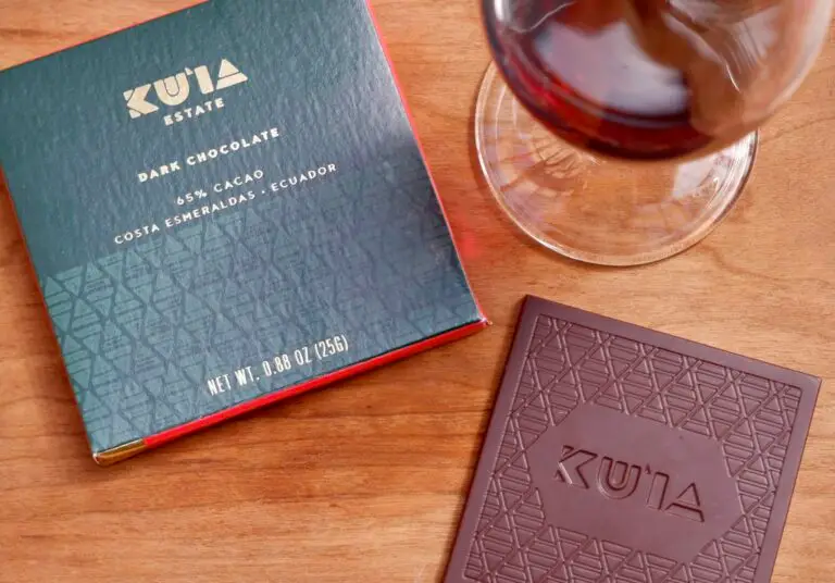 Maui Kuʻia Estate dark chocolate bar beside a glass of Lehua raspberry wine