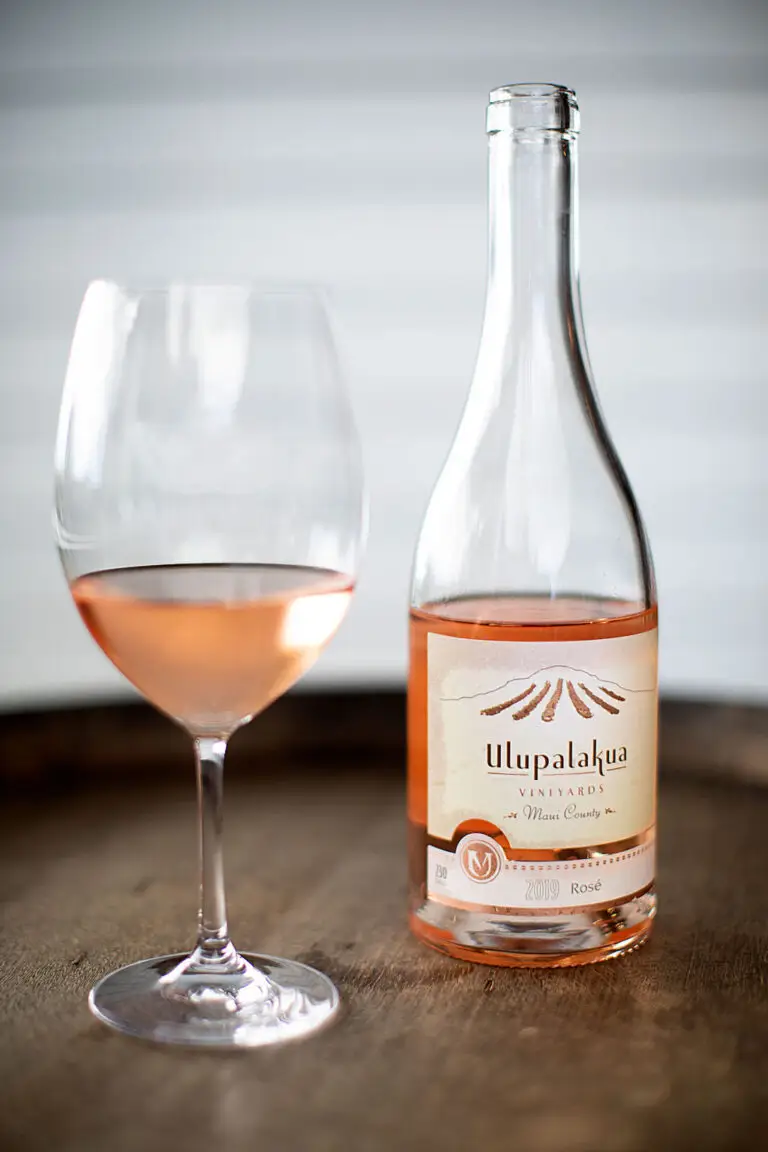 Bottle and glass of Ulupalakua Vineyards Rosé on a wooden barrel
